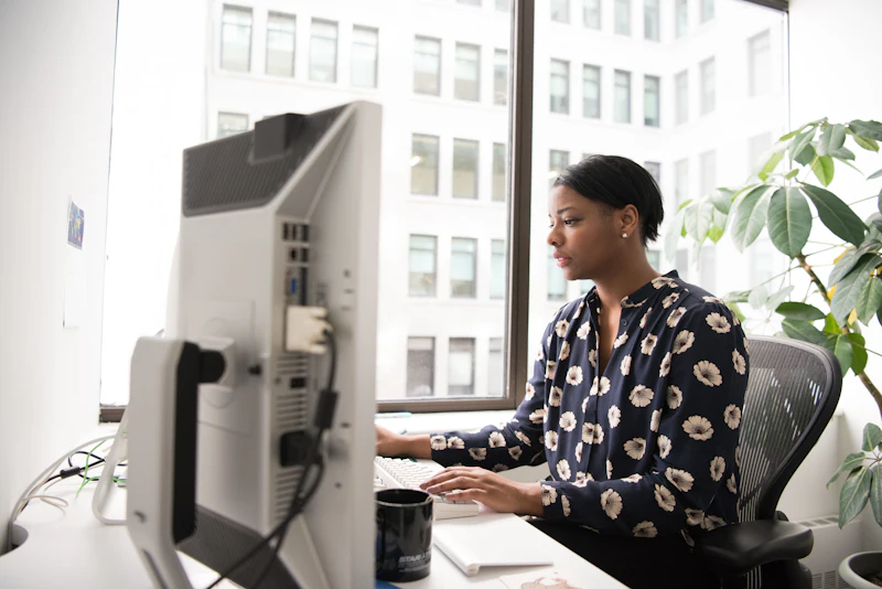 Een professional werkt aan een website achter een groot scherm in een licht kantoor.